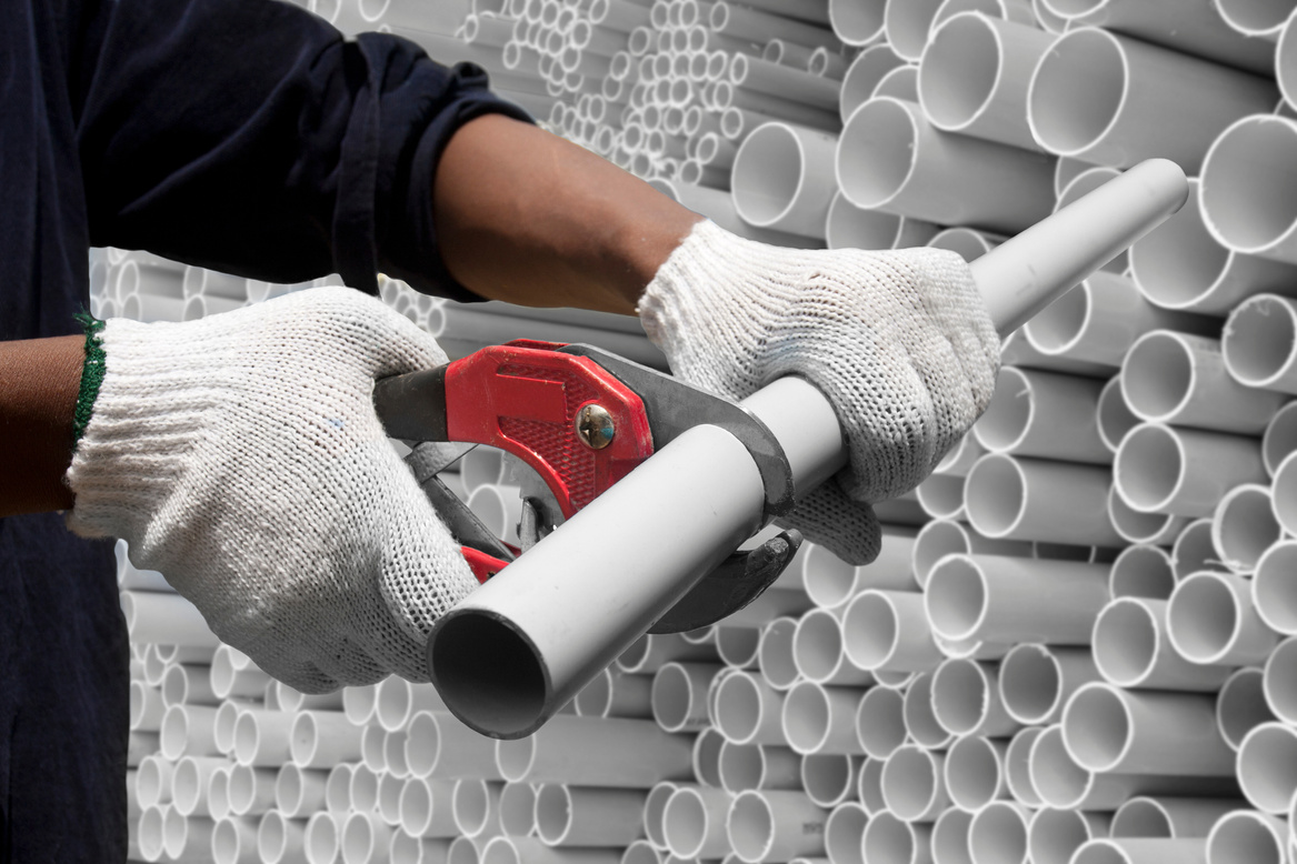 Worker Cutting a PVC Pipe         