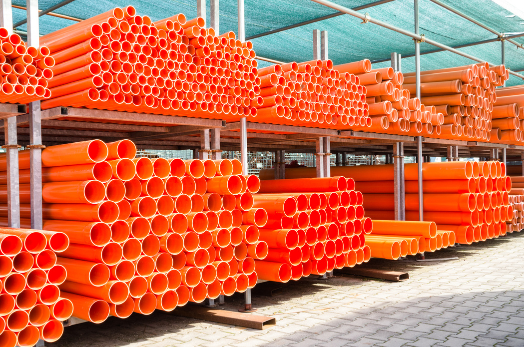 Stack of Orange Pvc Water Pipes